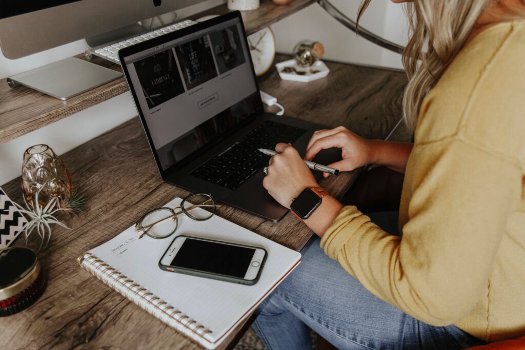 Woman with laptop writing phone by the side