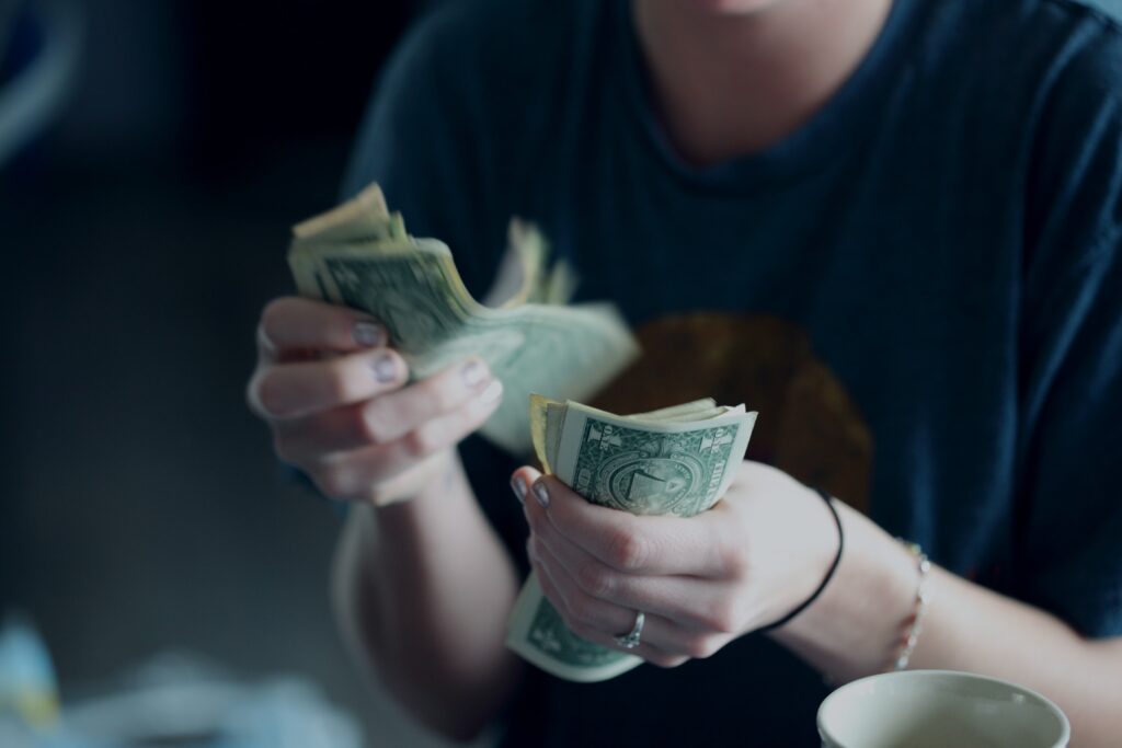 A twenty-four year old woman counting dollar bills