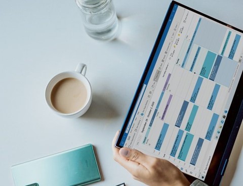 A person holding a tablet with an Excel table open.