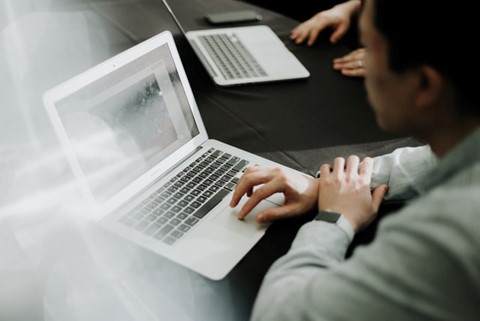 A man in front of a computer thinking about how to use email to get backlinks without being spammy.