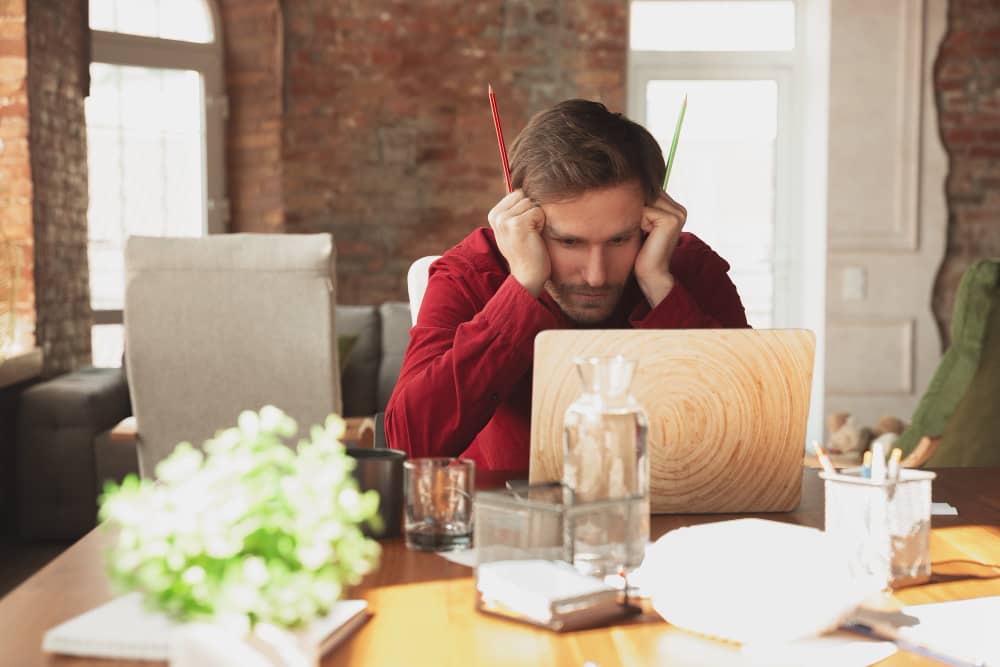 Frustrated man looking at his laptop