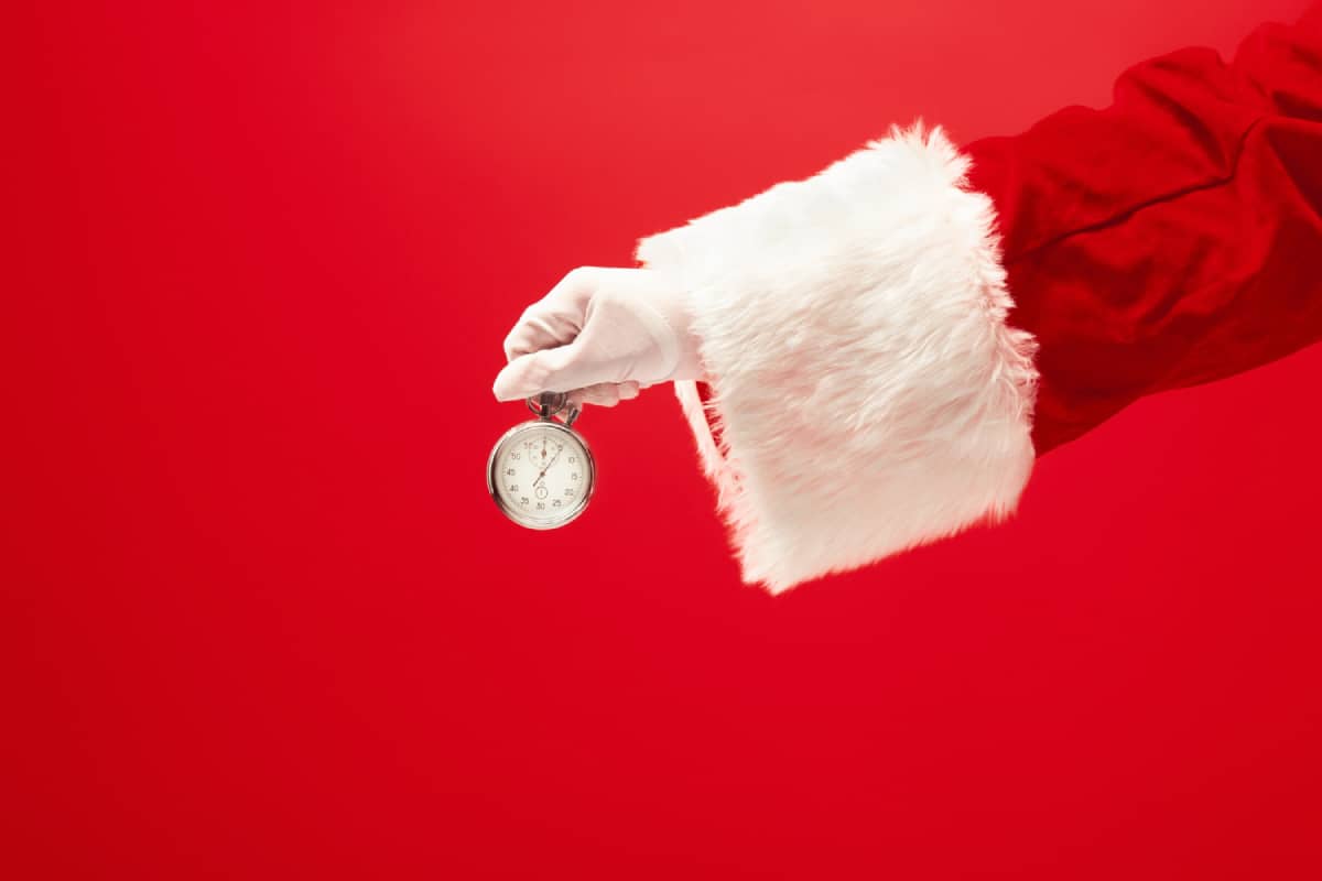 Santa holding a stopper watch in a red background