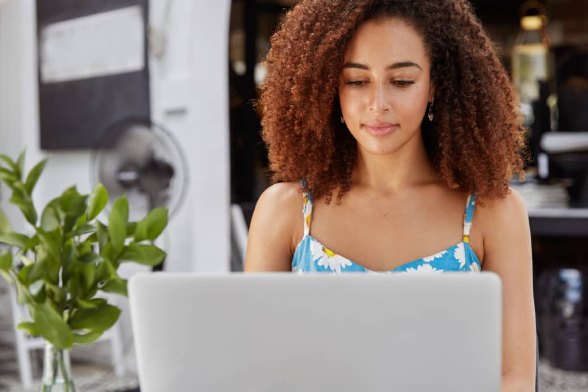 Busy and content woman focused behind her laptop