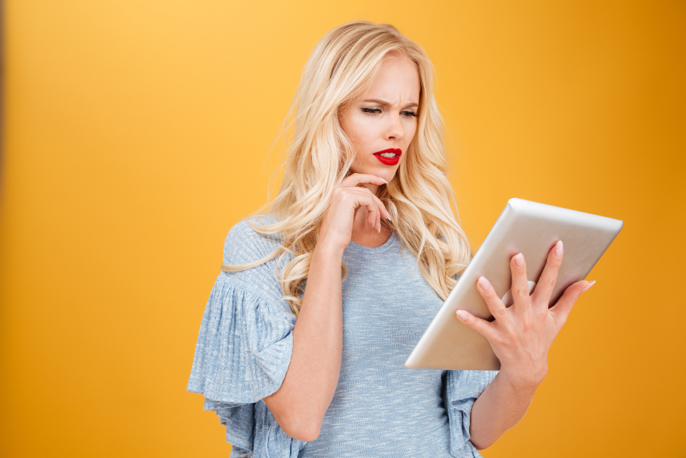 Confused young woman using a tablet computer email marketing