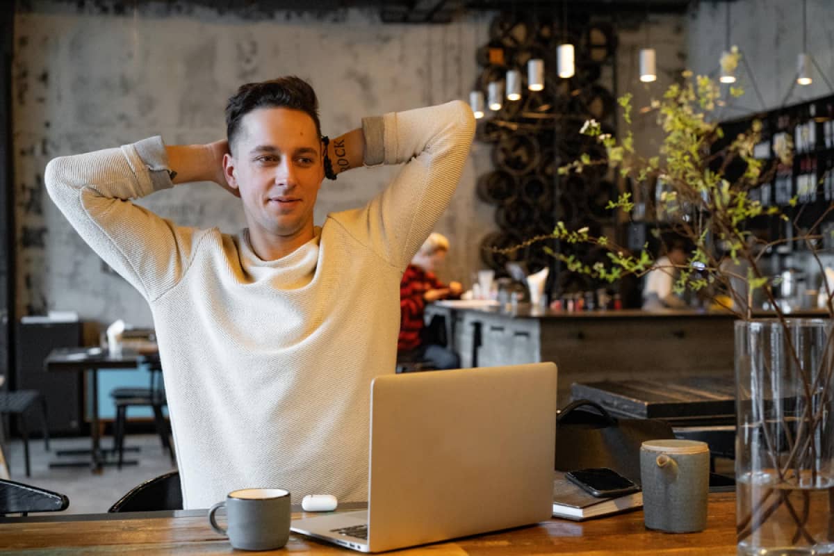 Young email marketing man relaxing behind laptop on a workday at the coffee shop