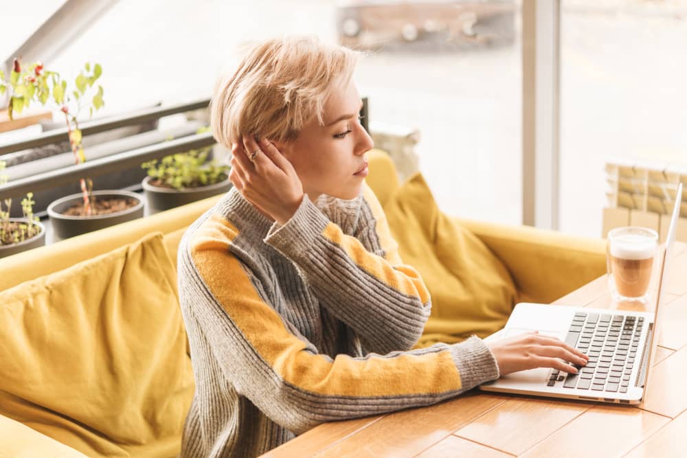 Email marketer working with laptop in a coffee shop