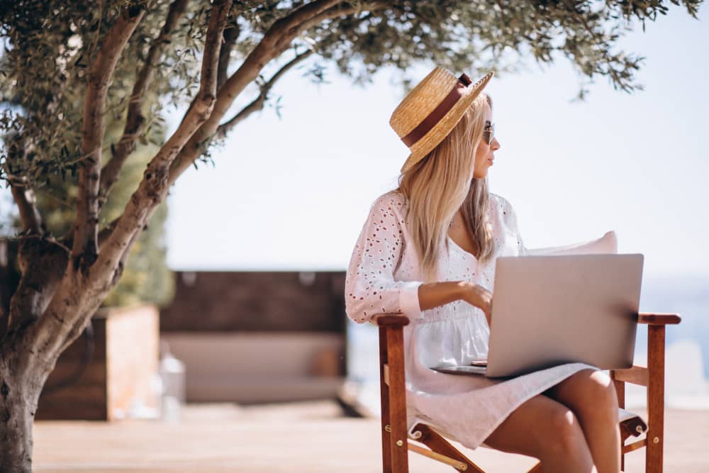 Woman on laptop in tropical climate, symbolizing email segmentation based on location