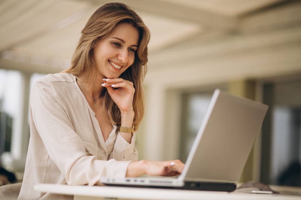 B2B business woman working on laptop and smiling