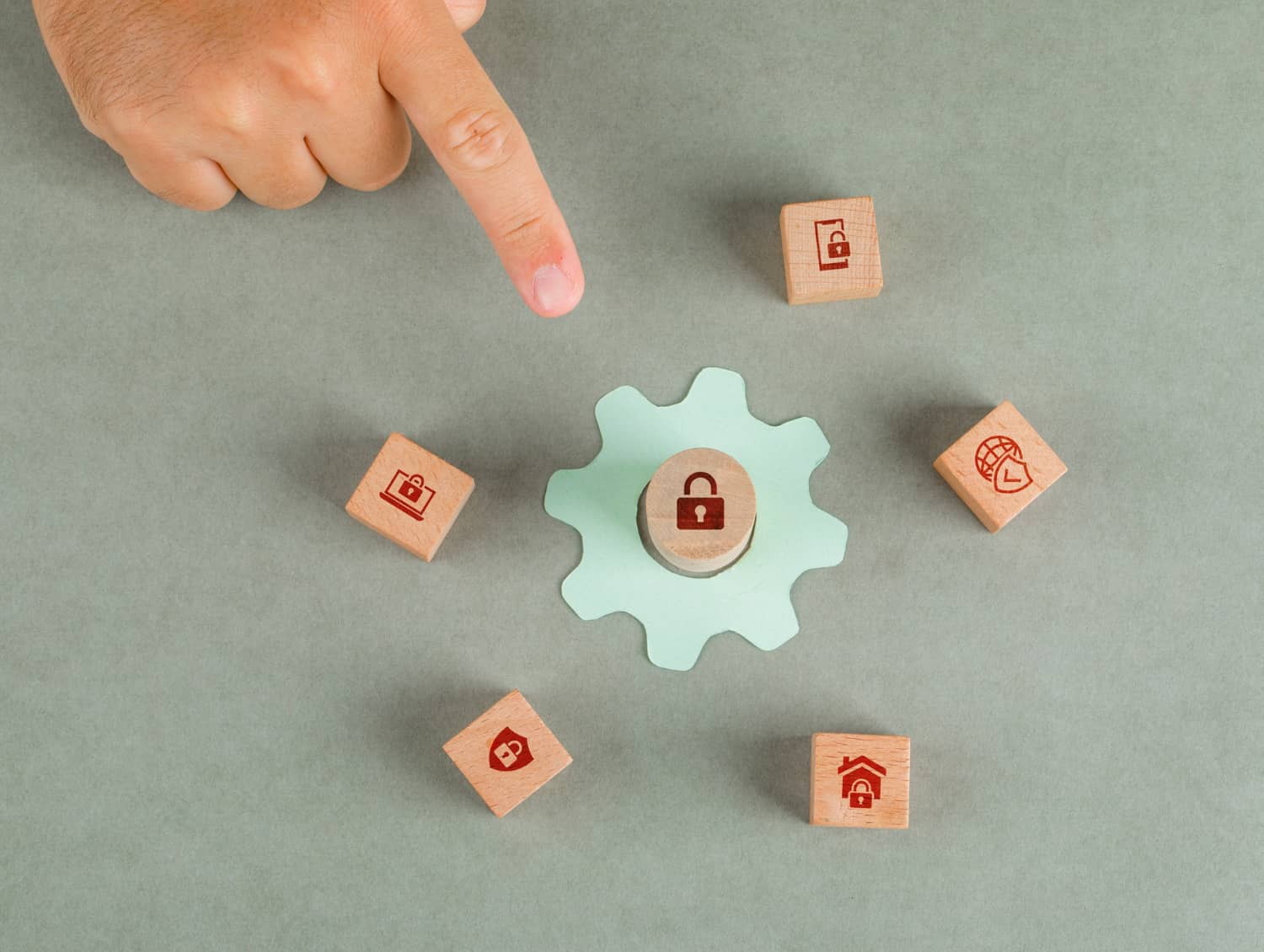 Conceptual image of privacy - hand pointing to wooden blocks with icons