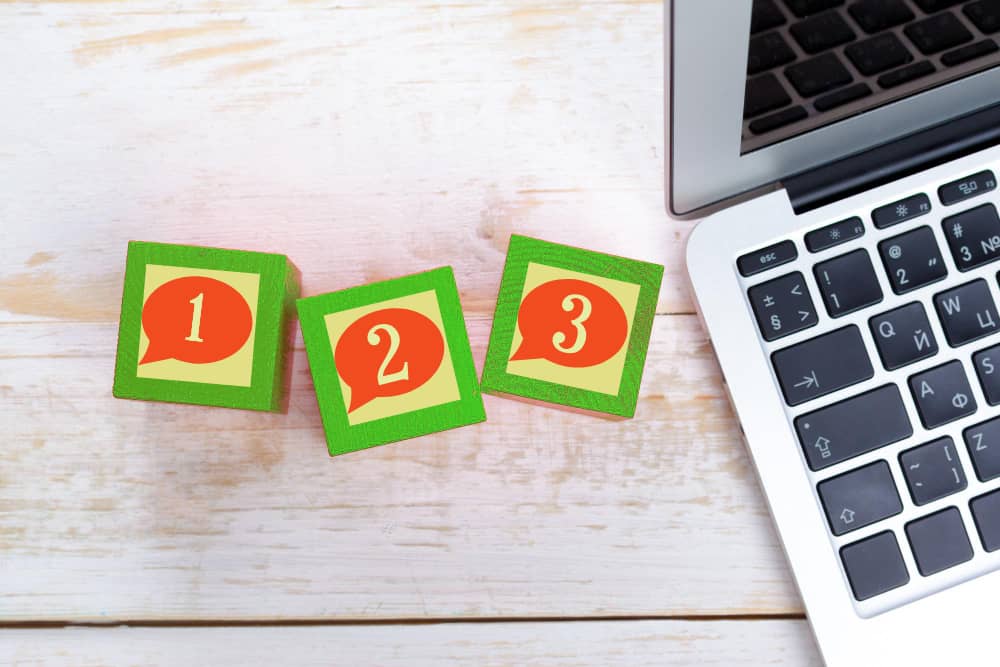 Laptop with wooden cubes symbolizing welcome email sequence