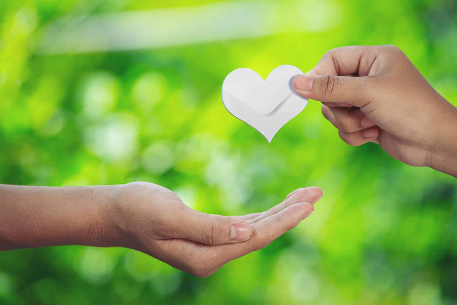 Person giving a heart shaped envelope, symbolizing a welcome email