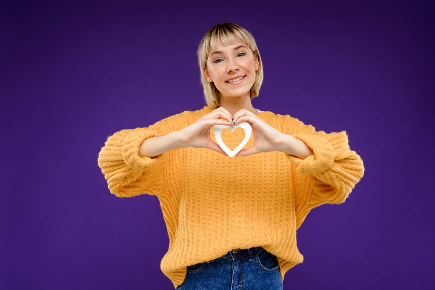 Young woman holding heart expressing gratitude