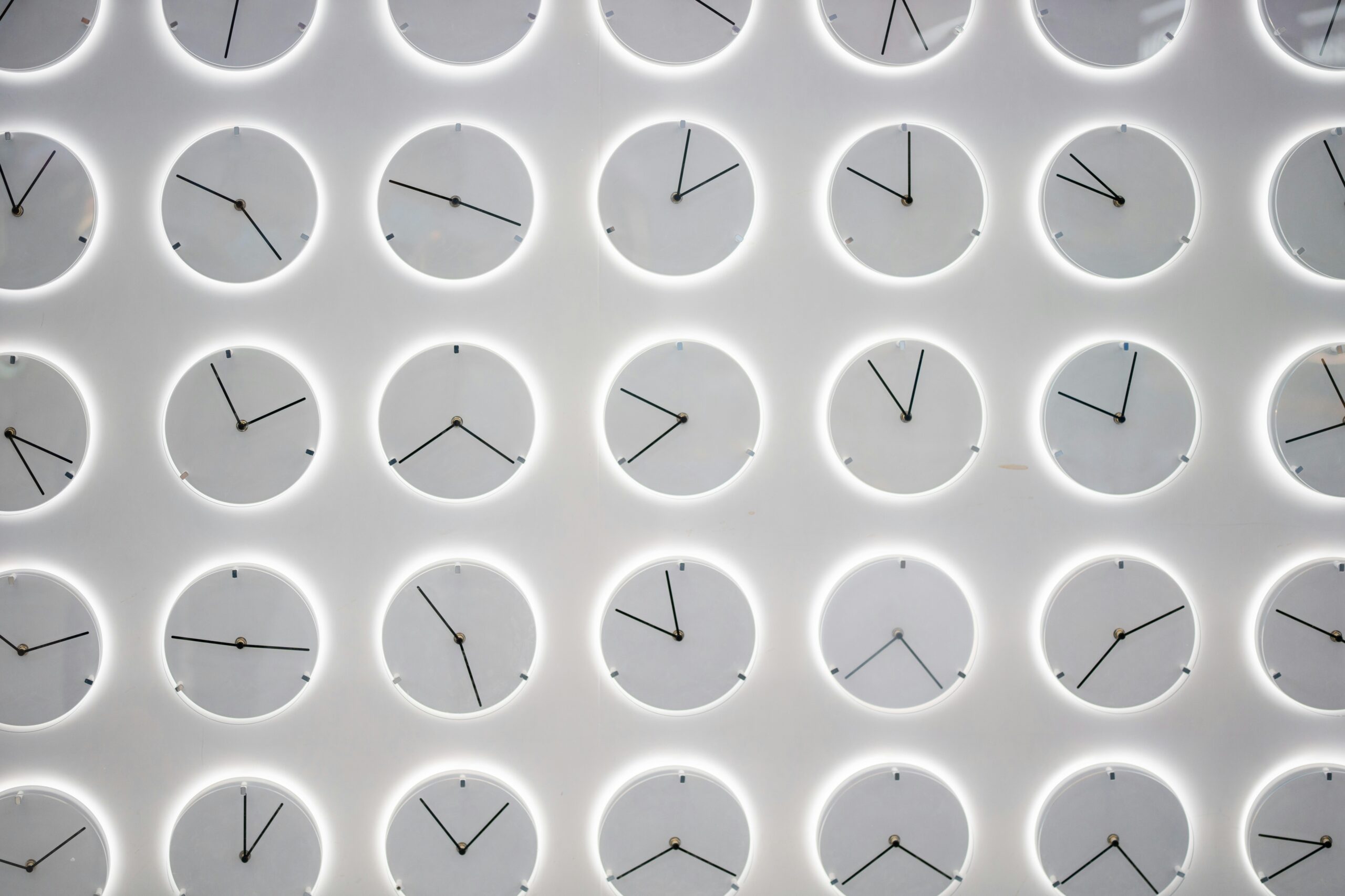 Clocks on a white wall showing different time zones