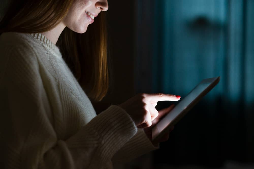 Woman looking at screen in dim light