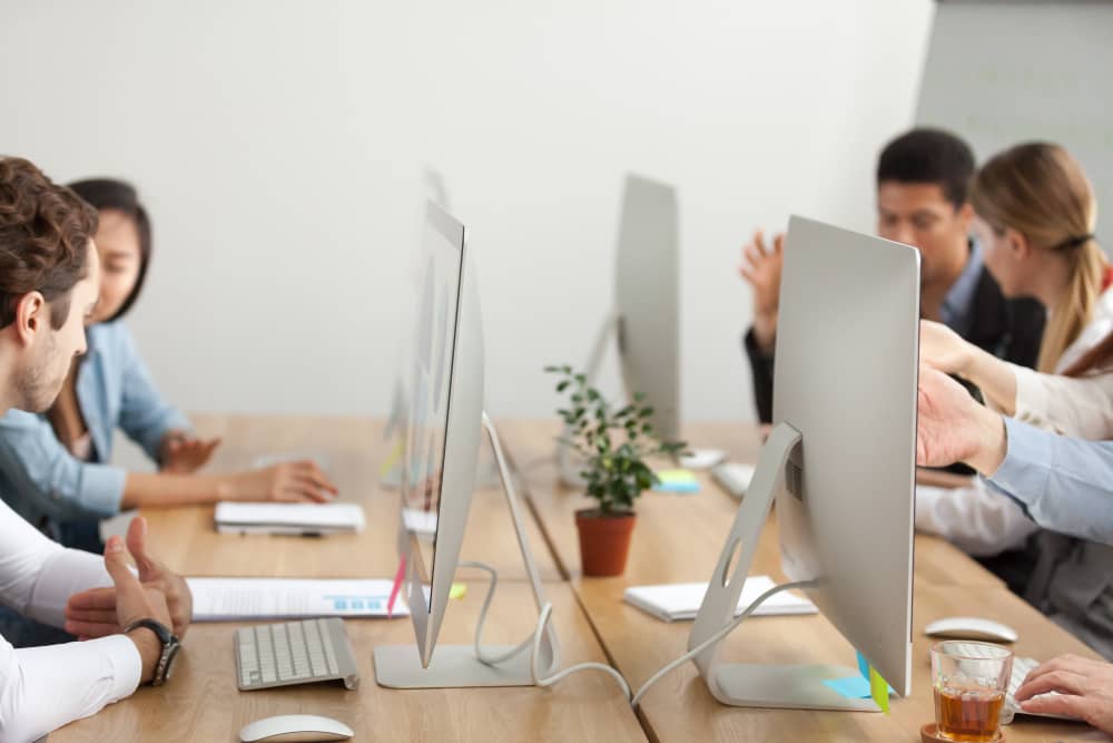 People working in an office behind computers learning email etiquette