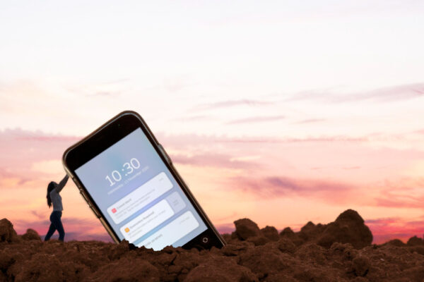 Person pushing a gigantic mobile phone, symbolizing push notifications and email marketing