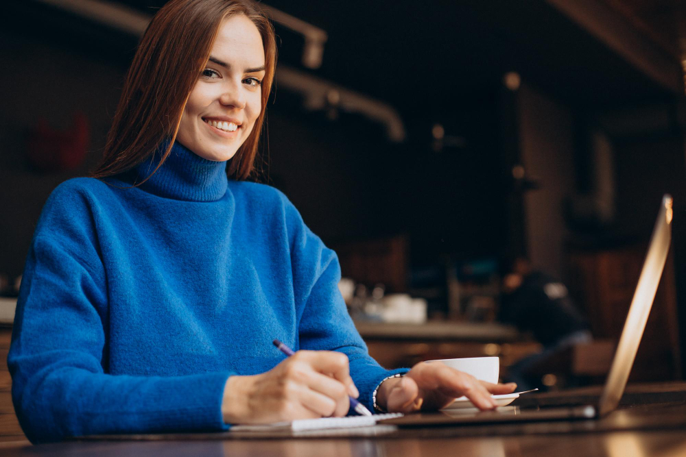 Happy smiling email marketer behind her laptop