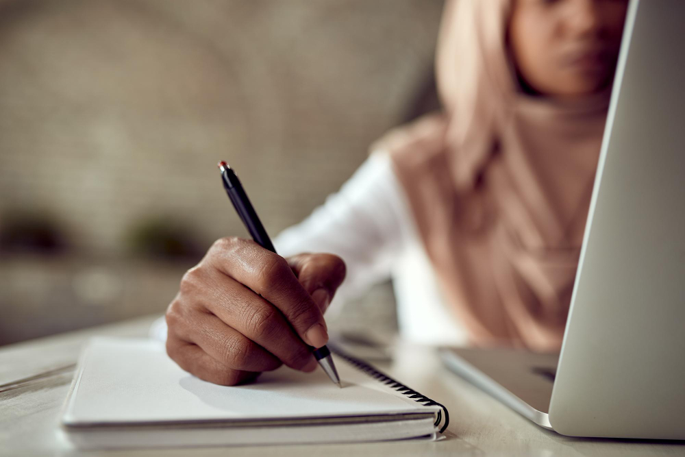 Woman writing down, planning email marketing strategies