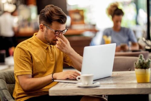 Person feeling tired while working behind a computer
