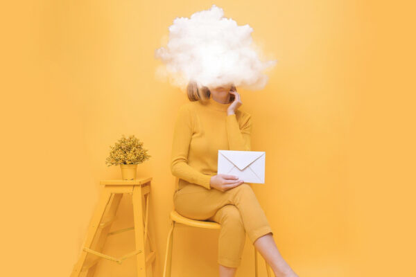 Woman with an envelope in hand and head in clouds, symbolizing short email attention span