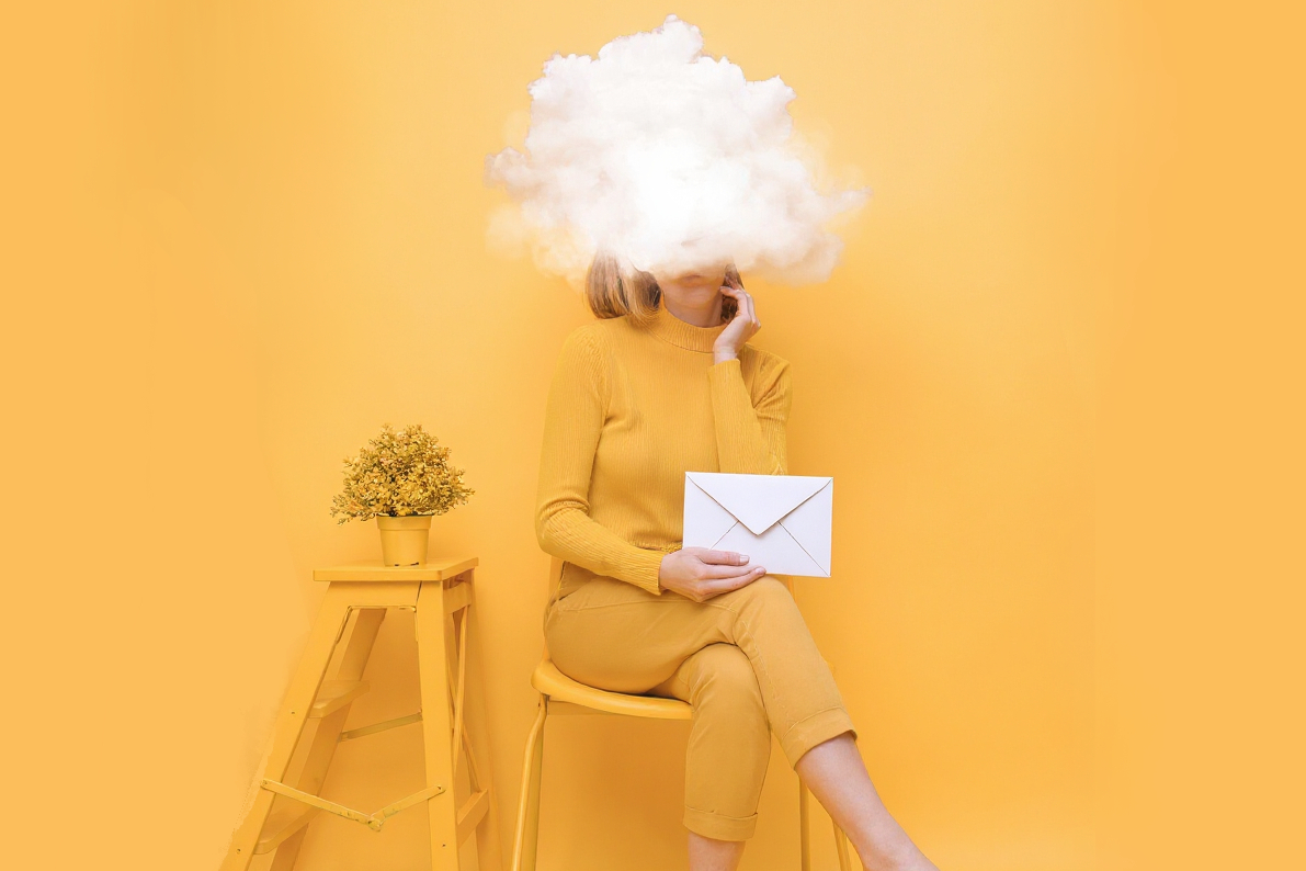 Woman with an envelope in hand and head in clouds, symbolizing short email attention span