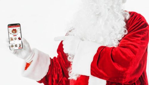 Santa Claus showing Christmas offer email on a mobile phone screen