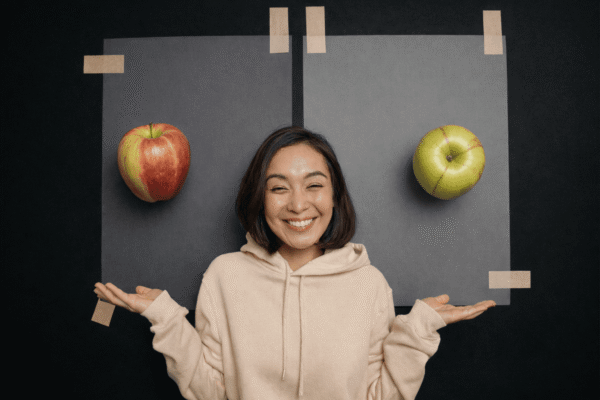 AB Testing Best Practices visual: woman comparing two apples on grey boards.