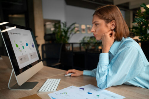 A marketer concentrating and looking at statistics from her computer screen