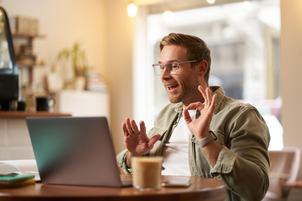 A marketer making a funny face behind his computer after making a joke, symbolizing humor in email marketing