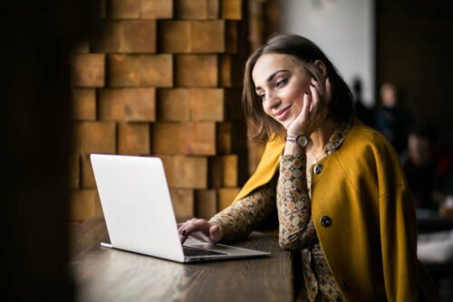 Happy person being in her laptop in a coffe shop