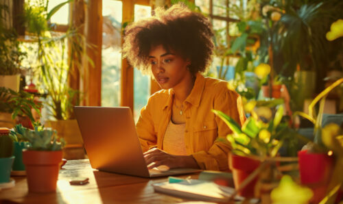 Person behind a laptop in a colorful room doing research on a product they're interested in