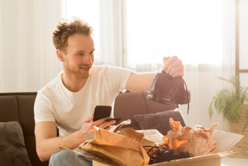 A happy online shopper opening a box with his new running shoes