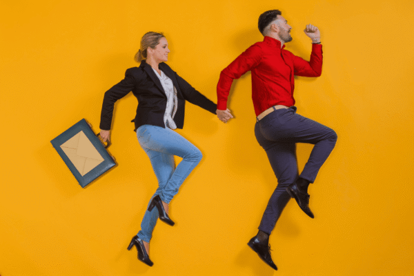 A man leading a woman with a suitcase with an envelope hand-in-hand, symbolizing email spam triggers