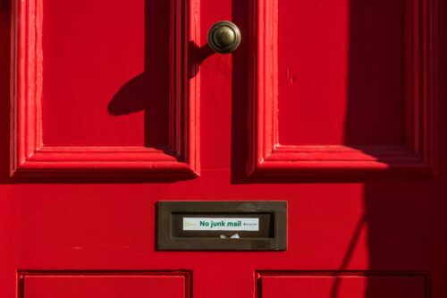 A red door with the text 'no junk mail' on it