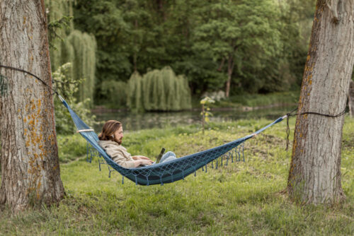 Email marketer working in a hammock in the summertime