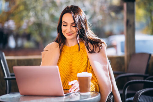 A smiling email marketer having coffee and working