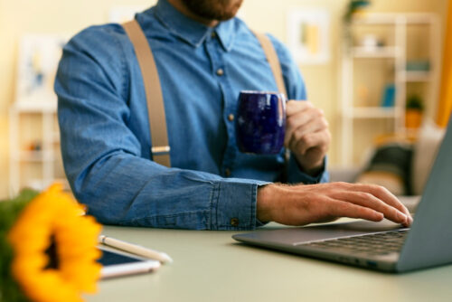 Person enjoying coffee, looking at offers on their computer