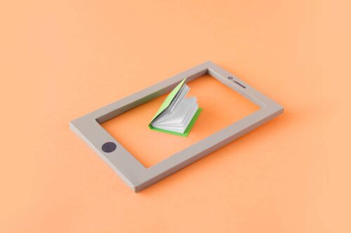An illustration of books representing knowledge displayed on a digital device, symbolizing cognitive fluency and information processing in email marketing